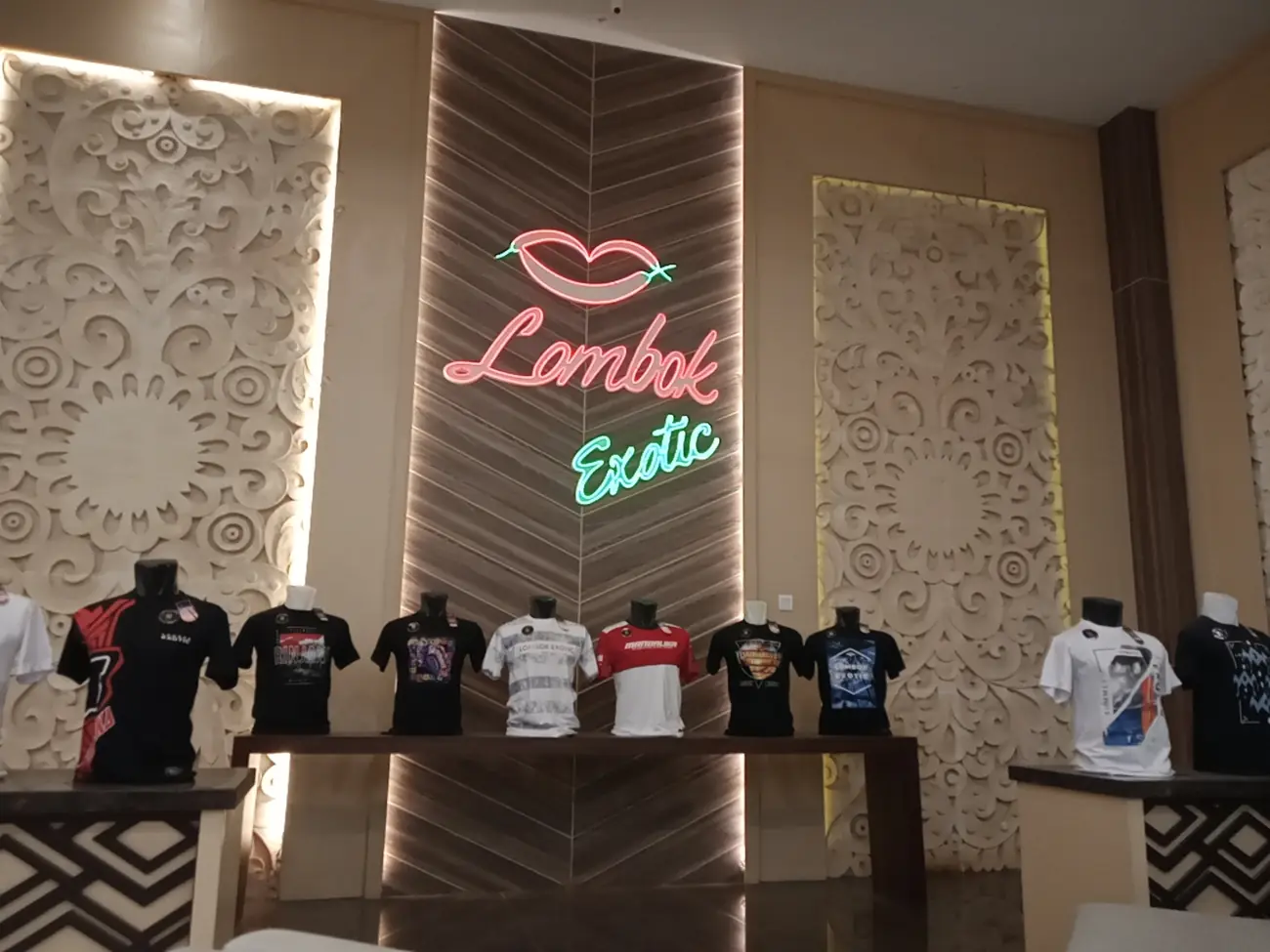 Kaos bergambar Lombok dipajang di bawah papan neon bertuliskan Lombok Exotic