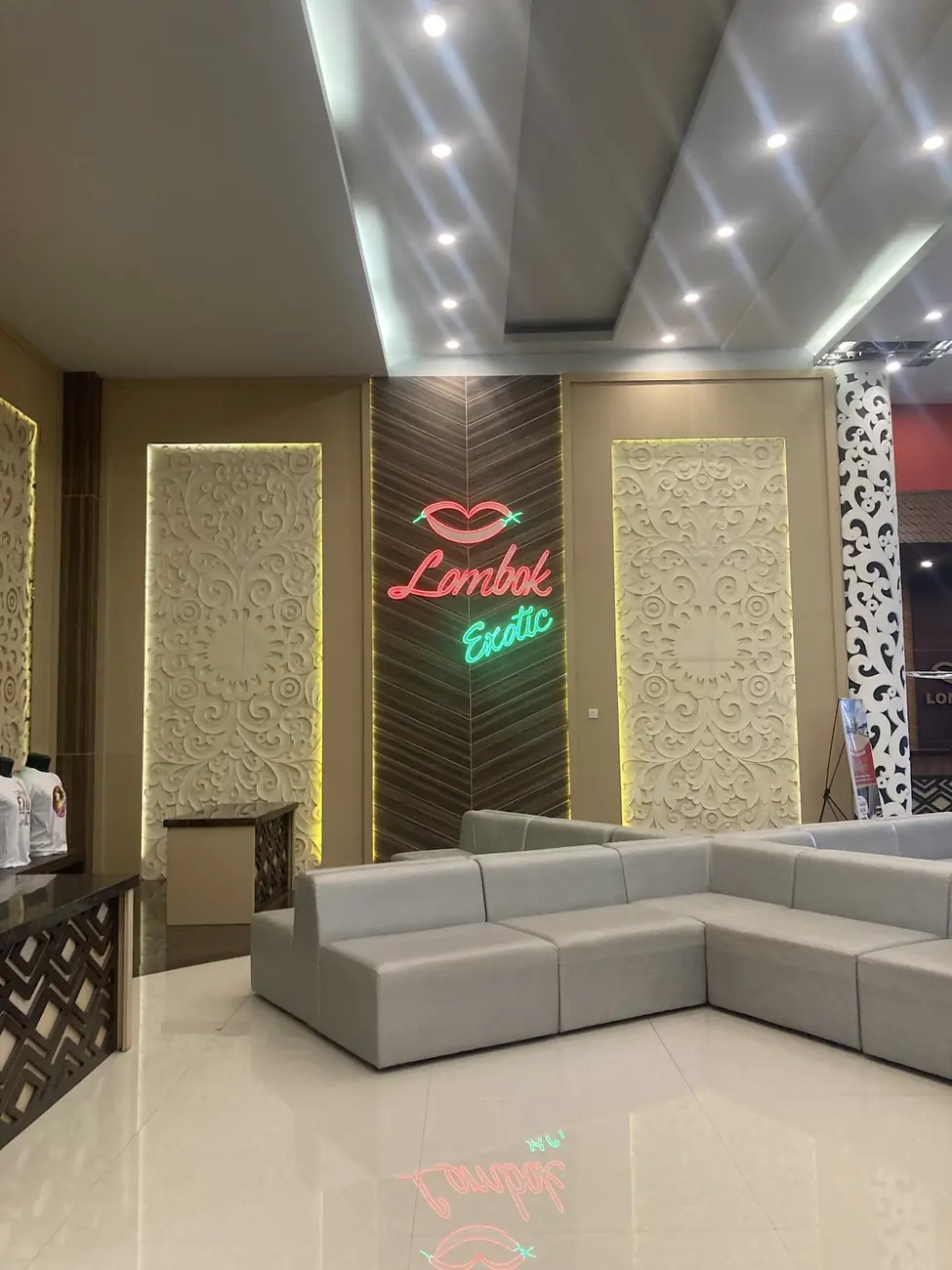 Ruang tunggu dengan sofa dan papan neon kecil